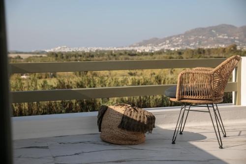 a chair and a basket on a porch with a view at Naxian green life in Agia Anna Naxos