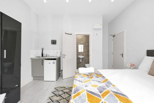 a white bedroom with a bed and a sink at Luxury Hackney Suites in London