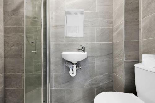 La salle de bains est pourvue d'un lavabo et de toilettes. dans l'établissement Luxury Hackney Suites, à Londres