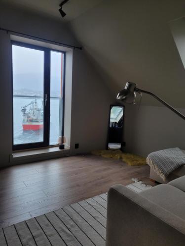 a living room with a large window with a boat in the water at Single Elegant Room i sentrum- Sea View in Ålesund