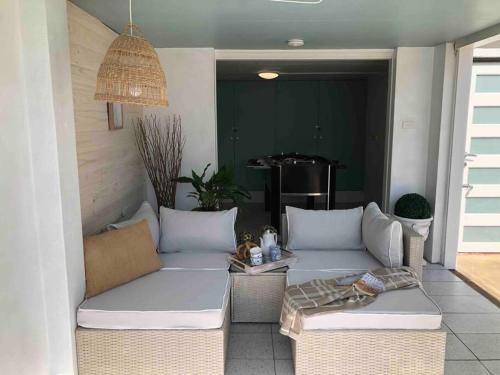 a patio with two white couches and a table at Modern Farmhouse at Pacific Sands Mollymook Beach in Mollymook