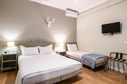 a hotel room with two beds and a tv at La Piazzetta Rooms & Apartments in Genova