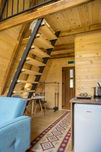 a room with wooden walls and wooden stairs in a cabin at Mountain Houses Emilija in Žabljak