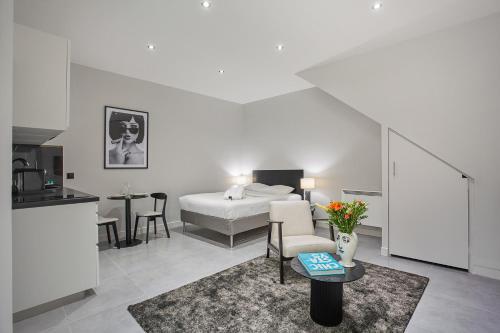 een slaapkamer met een bed en een keuken met een tafel bij Residense Montmartre by Studio prestige in Parijs