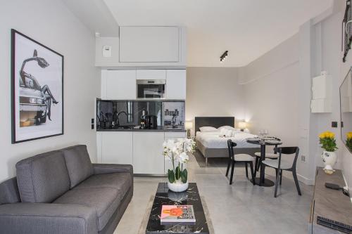 een woonkamer met een bank, een bed en een tafel bij Residense Montmartre by Studio prestige in Parijs