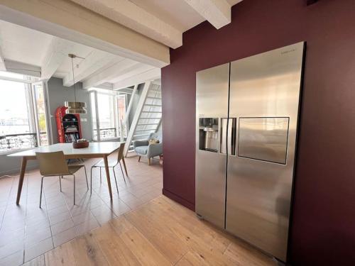 Il comprend une cuisine et une salle à manger avec un réfrigérateur en acier inoxydable. dans l'établissement Unique appartement Vieux Port, à La Ciotat