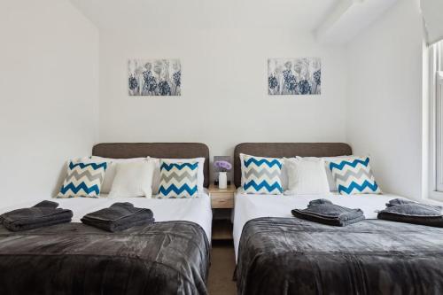 two beds sitting next to each other in a room at Luxury Urban Living - 1 BDR in London