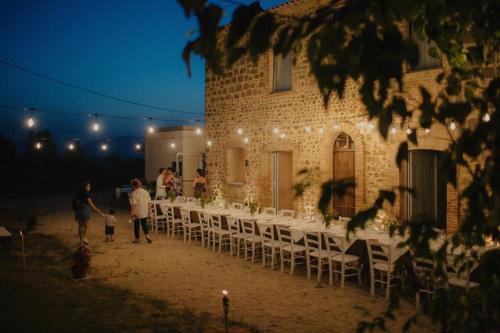 a group of people standing outside of a building with tables and chairs at Arcadia Agriturismo in San Nicola Manfredi