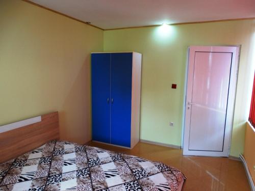 a bedroom with a blue cabinet and a door at Apartaments Viktoria in Silistra