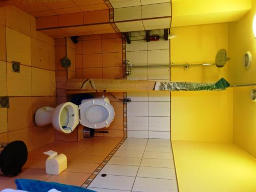 a bathroom with a toilet and a yellow wall at Apartaments Viktoria in Silistra