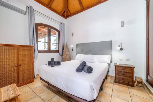 a bedroom with a large white bed and a wooden ceiling at Villa Loira in Corralejo
