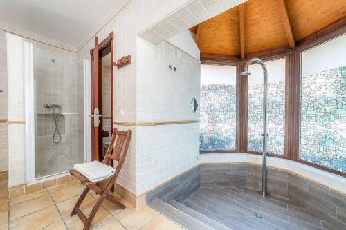 a bathroom with a shower and a chair at Villa Loira in Corralejo