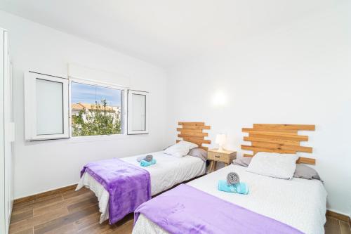 duas camas num quarto com duas janelas em Townhouse Forteza By homevillas360 em Colonia de Sant Pere