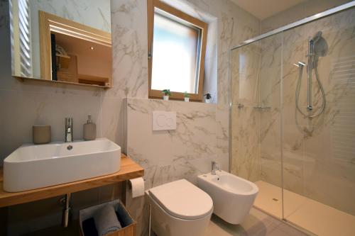 a bathroom with a sink and a toilet and a shower at Design Residence Nellere II in Padola