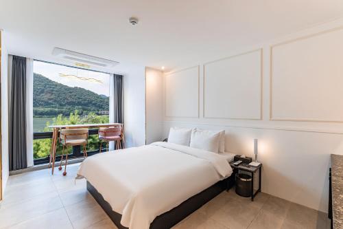 una camera d'albergo con un letto e una grande finestra di The Amber Hotel a Yangpyeong