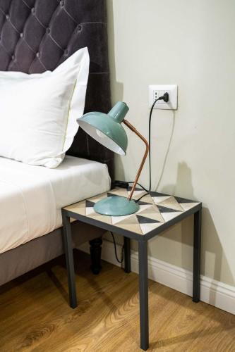 a table with a lamp on it next to a bed at La Piazzetta Rooms & Apartments in Genova