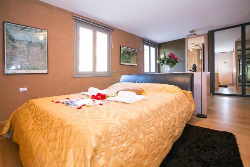 ヴァレンナにあるDella Fontana Penthouseのベッドルーム1室(花の飾られたベッド1台付)