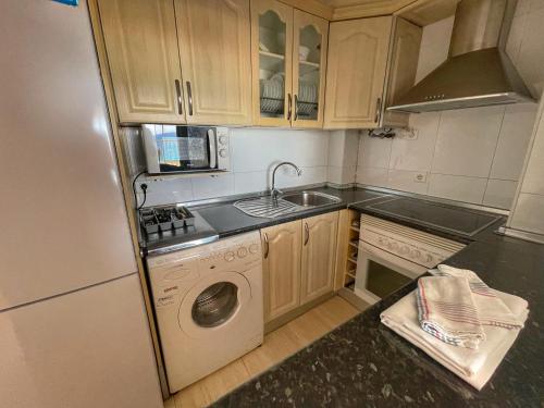 a kitchen with a refrigerator and a sink and a dishwasher at Levante Trip - Family Apartments in Benidorm