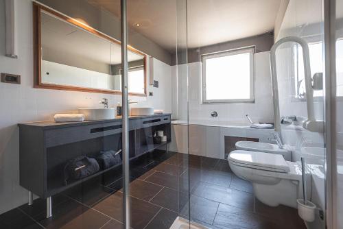 a bathroom with a toilet and a sink and a shower at Vitalpina Hotel Waldhof in Rablà