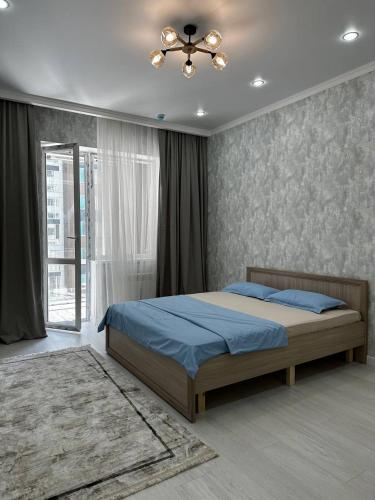 - une chambre avec un lit et un ventilateur de plafond dans l'établissement Expo Avenue, à Taldykolʼ