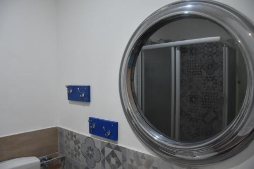 a bathroom with a round mirror and a toilet at AA Central Station Historical center in Palermo