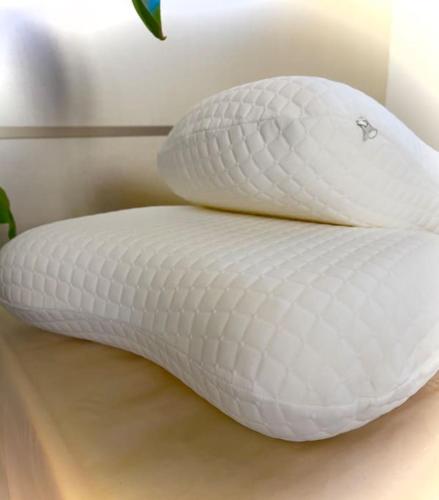 two white pillows sitting on top of a bed at Poppy • ecoGuestHouse in Venturina Terme