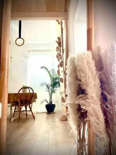 a living room with a chair and a table with feathers at Poppy • ecoGuestHouse in Venturina Terme