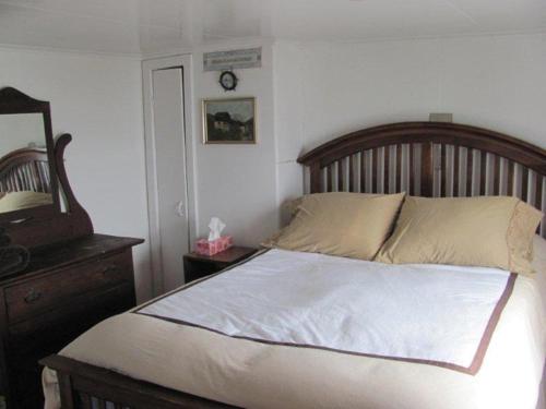 1 dormitorio con cama, tocador y espejo en Wolf Cove Retreat House, en Amherst Cove