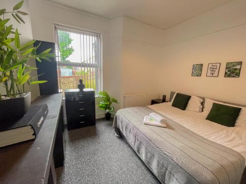 een slaapkamer met 2 bedden en een groot raam bij Rock Lane House by Serviced Living Liverpool in Rock Ferry