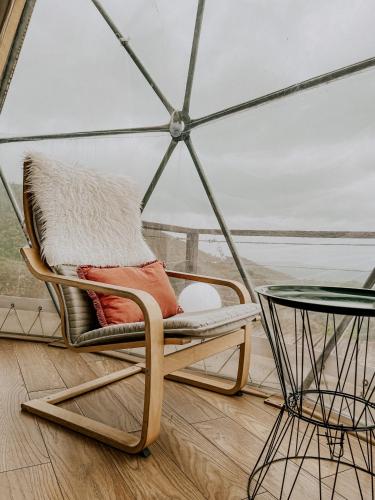 a chair and a table in a room at Natura Glamping in Alcongosta
