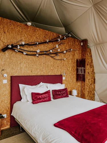 a bedroom with a bed with two red pillows at Natura Glamping in Alcongosta