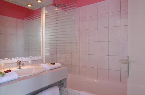 a bathroom with a sink and a tub and a mirror at LOGIS Le Pot D'Etain in Holnon