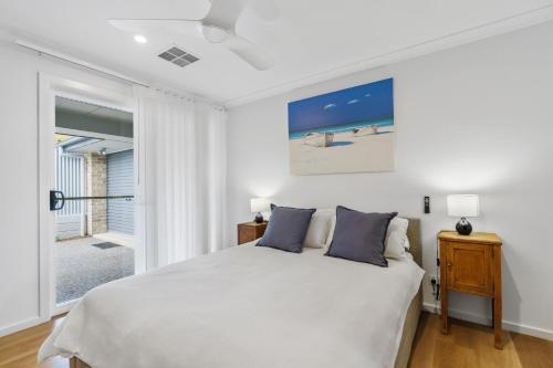 - une chambre blanche avec un lit et une fenêtre dans l'établissement 14 Chibnall St Port Elliot, à Port Elliot