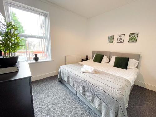 a bedroom with a bed with a plant on it at Rock Lane House by Serviced Living Liverpool in Rock Ferry