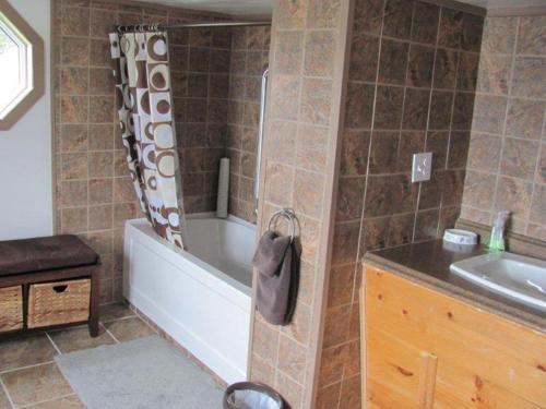 y baño con bañera y lavamanos. en Wolf Cove Retreat House, en Amherst Cove
