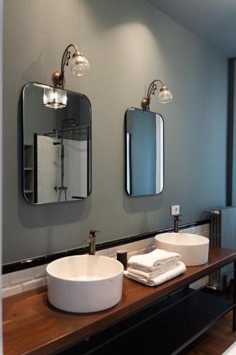 two sinks in a bathroom with two mirrors at Caffè delle Rose Les Chambres in Verbania