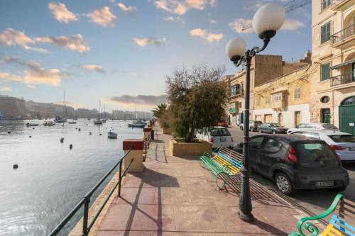 a street light next to a body of water with boats at Well Located Townhouse & Courtyard Kalka - Happy Rentals in Kalkara
