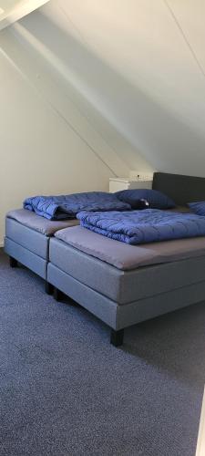 a bed with blue sheets in a room at Vakantiehuis 6pers op park 't Broeckhuys in Ewijk groot Zwemplas in het land van Maas & Waal niet voor arbeidsmigranten in Ewijk