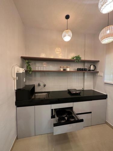 a kitchen with a black counter and a sink at Boho Studio in Pune