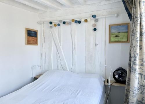 a bedroom with a white bed and a window at Le Mira - Paris centre - vue Tour Eiffel in Paris