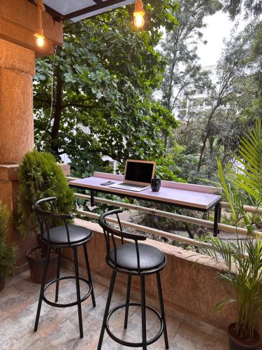 a table with two chairs and a laptop on a table at Boho Studio in Pune