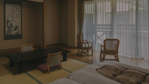 a living room with a dining room table and chairs at Kinasanoyu Hotel&Cottage in Nagano