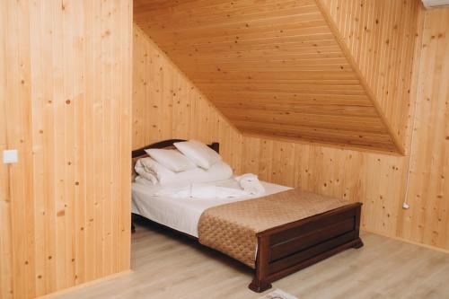 a bedroom with a bed in a wooden room at Holi Day in Solotvyno