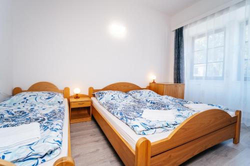 two twin beds in a room with a window at Lesák rekreační středisko in Chlum u Třeboně