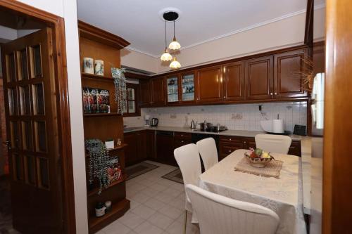 a kitchen with a table with white chairs and a tableablish at AnyfApartment Kalamata in Kalamata