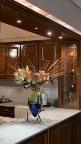 a vase of flowers on a counter in a kitchen at AnyfApartment Kalamata in Kalamata