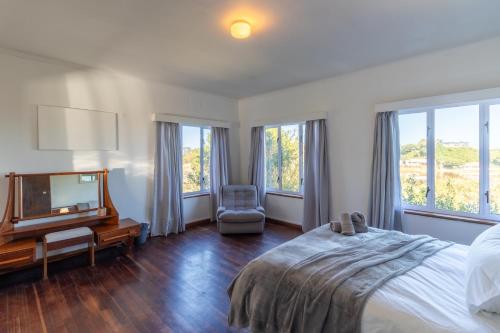 維德尼斯的住宿－Wilderness Holiday Home - Riverside，一间卧室设有一张床、一台电视和窗户。
