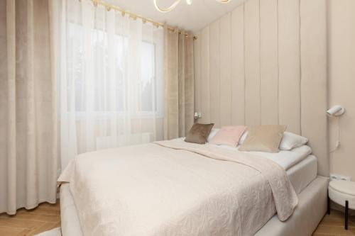 a white bedroom with a white bed and a window at Ursus Nova Apartment with Parking by Renters Prestige in Warsaw