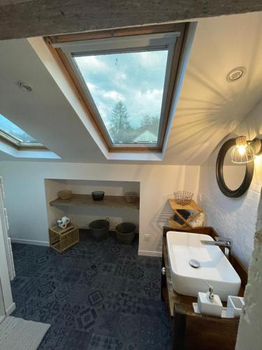 La salle de bains est pourvue d'un lavabo et d'une lucarne. dans l'établissement Gite le Montinho, à Fontevraud-l'Abbaye