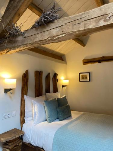 1 dormitorio con cama y vigas de madera en Ostalon de Sénégats en Lacaze
